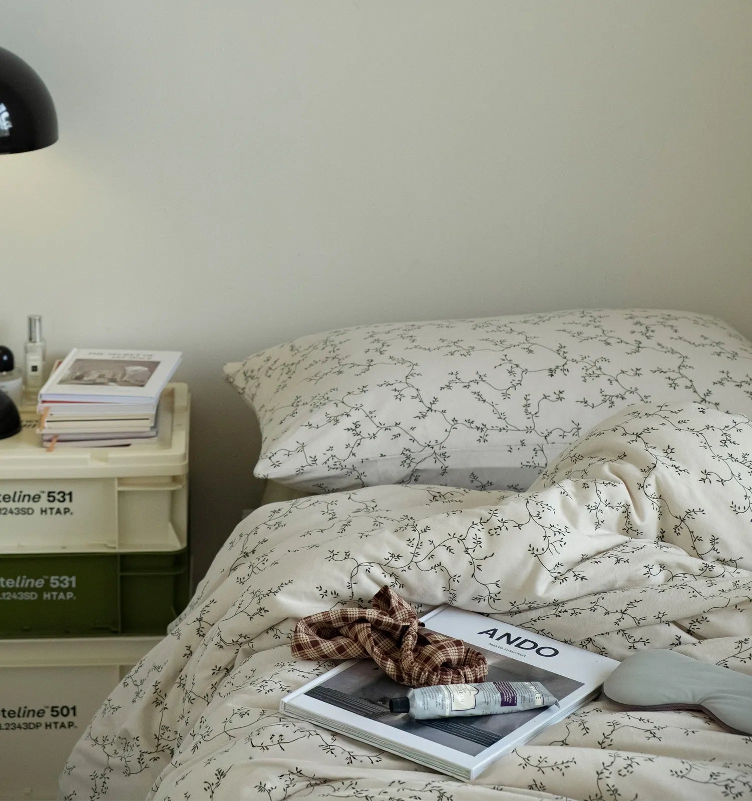Bedroom interior styling bedside table with books and floral bedding set RoomDen