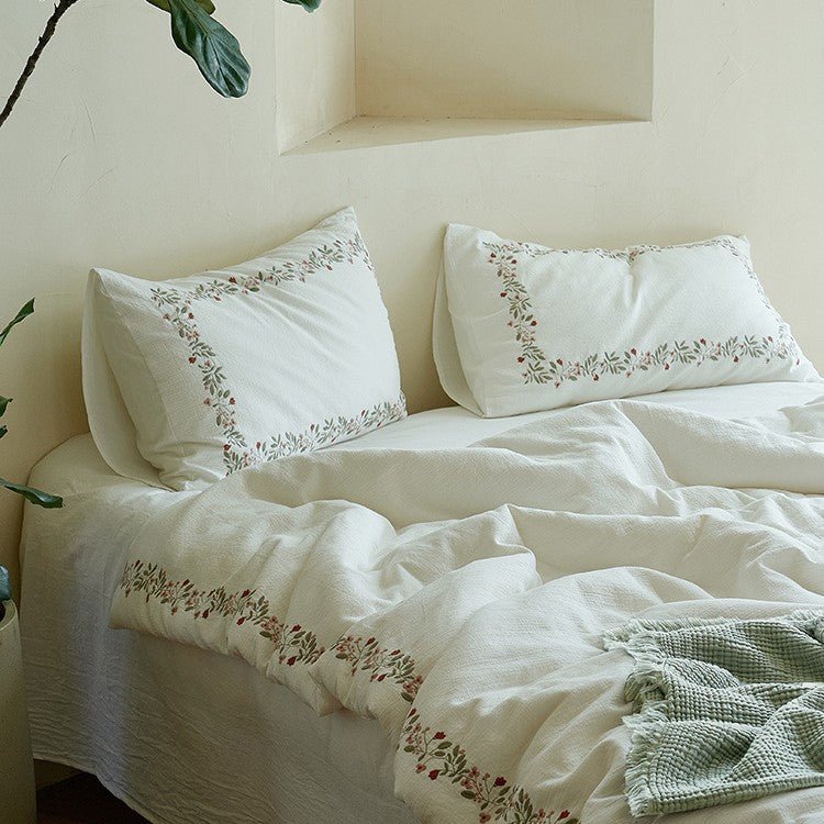 Ivory embroidered cotton gauze bedding set styled on a bed - Roomden