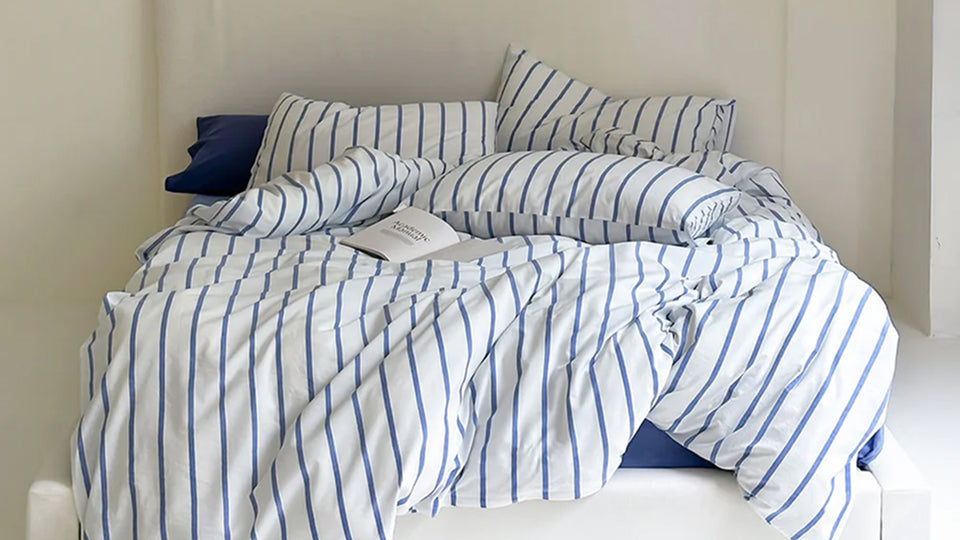 Overhead view of an aesthetic bedding collection, highlighting various materials and styles for comfortable layering.