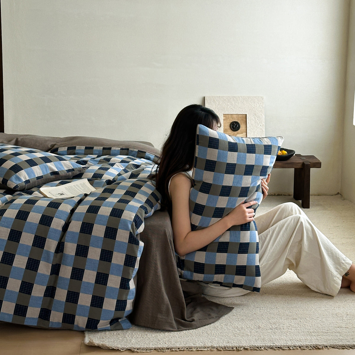 Gingham Jacquard Cotton Gauze Bedding Set – Denim Check, person holding the checked pillow - Roomden