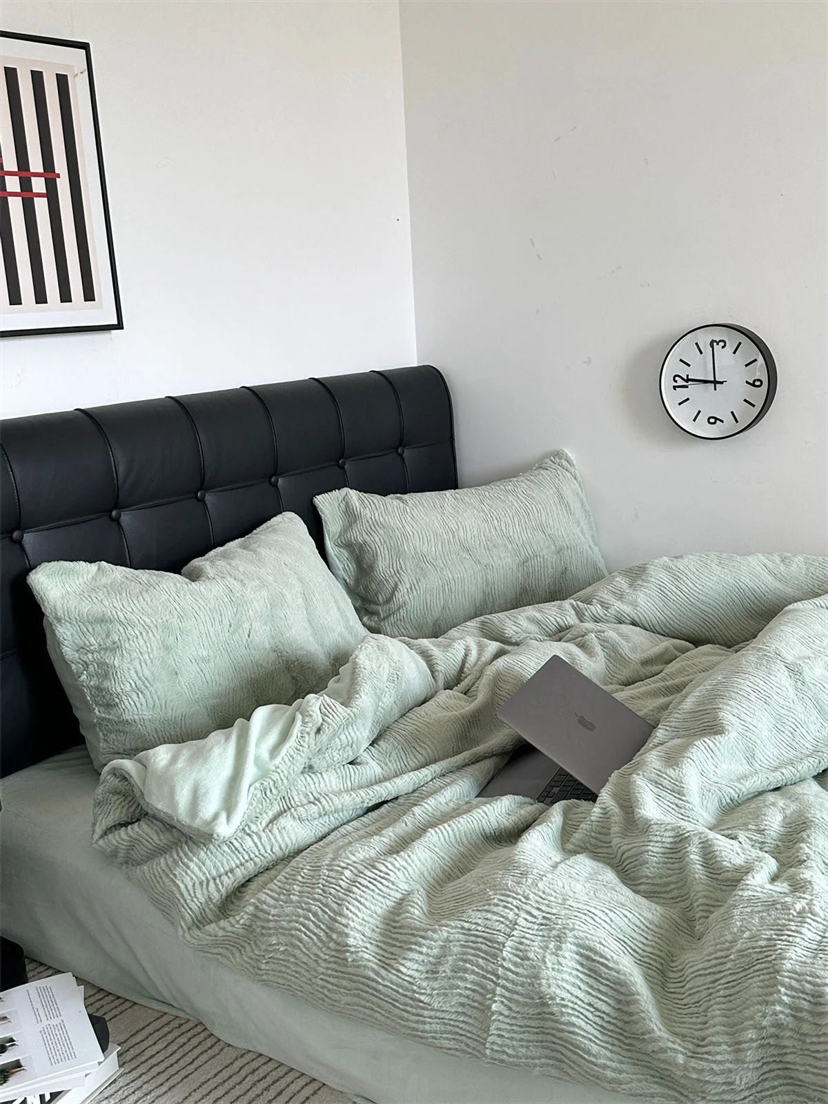 A Sage Green ruched flannel fleece bedding set against a black headboard in a minimalist bedroom. - RoomDen