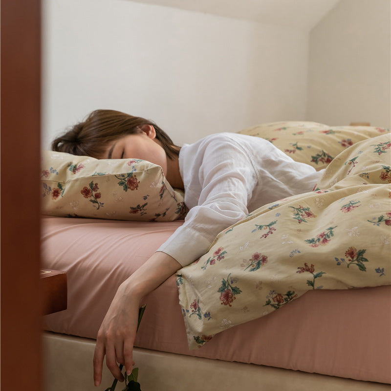 Buttercream Vintage Bouquet Cotton Bedding Set – side view of the floral duvet draped over a pink sheet - Roomden