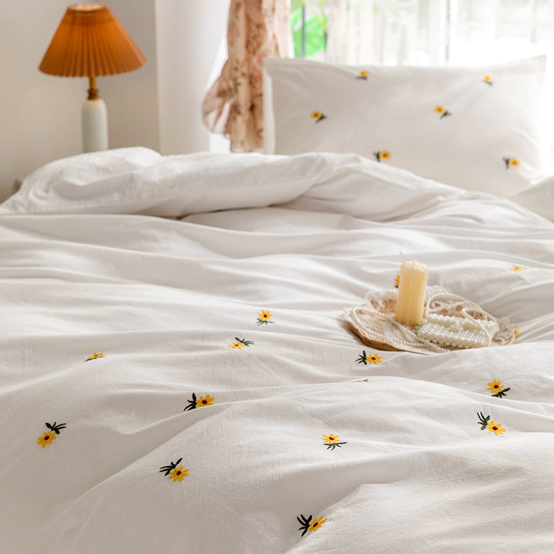 Daisy embroidered cotton bedding set – Low angle across the embroidered duvet toward the pillows - Roomden