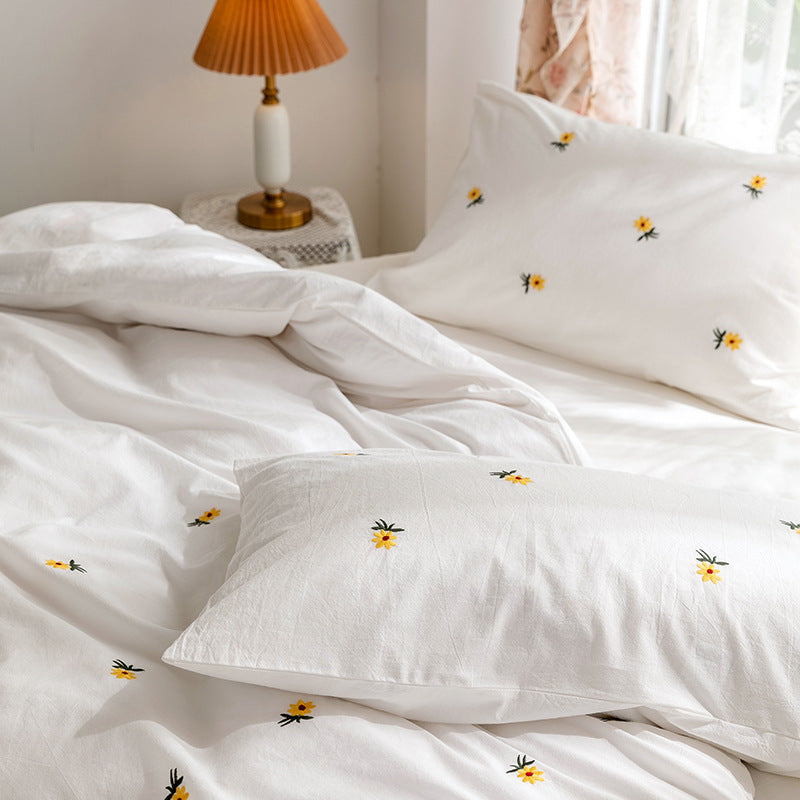 Daisy embroidered cotton bedding set – Relaxed folds and matching floral pillow beside the window - Roomden