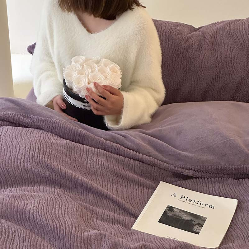 Wave textured plush bedding – dusty lavender wave ridges and smooth reverse beside the model - Roomden