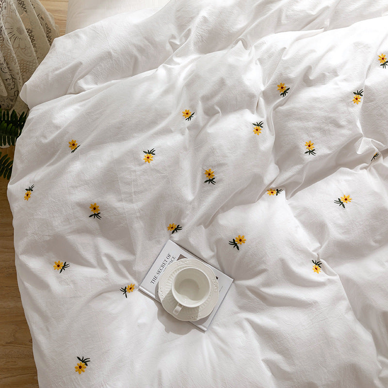 Daisy embroidered cotton bedding set – Close view of the scattered yellow flowers and cotton texture - Roomden