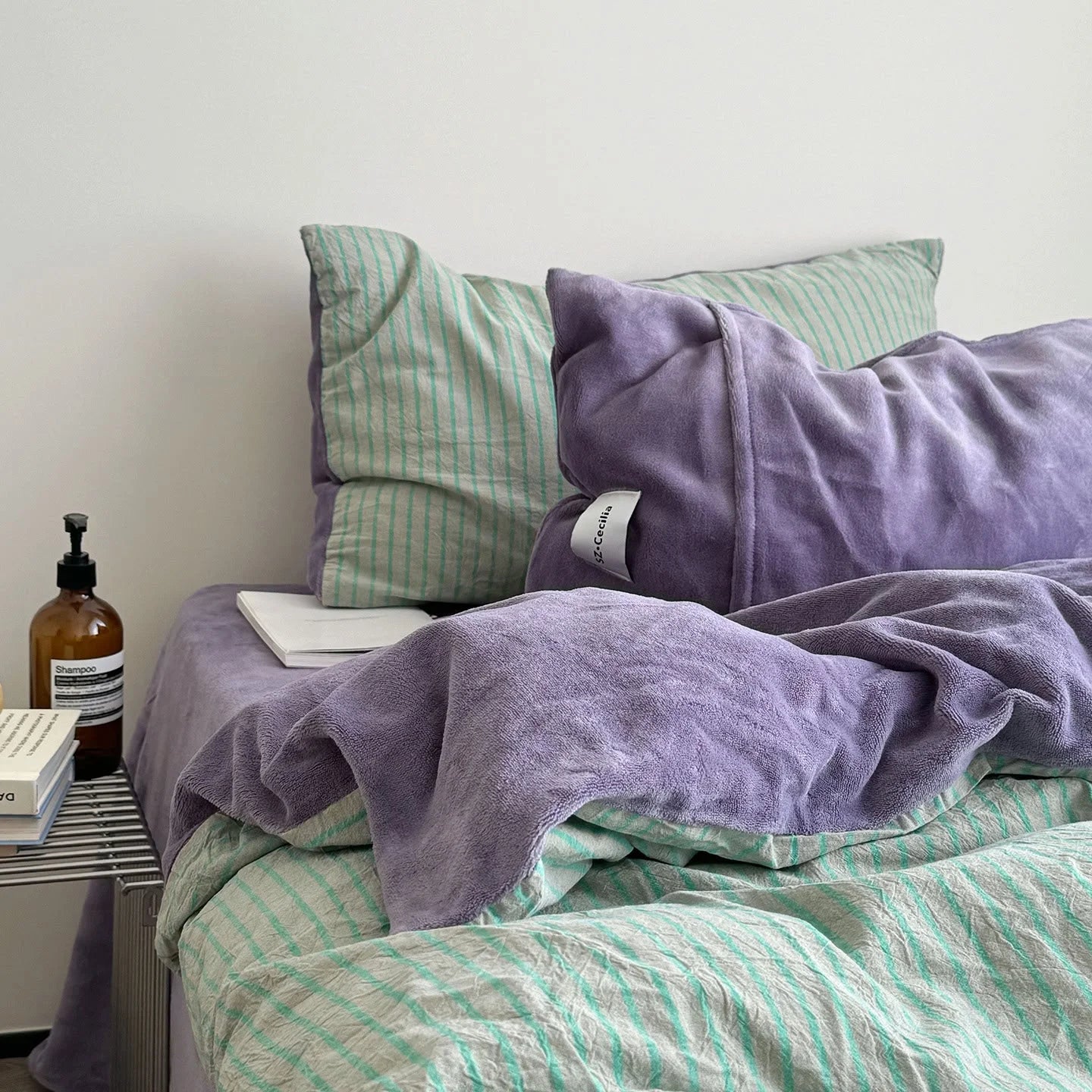 Lifestyle image of the Purple & Mint Striped Flannel Fleece Bedding Set in a bright, minimalist bedroom.