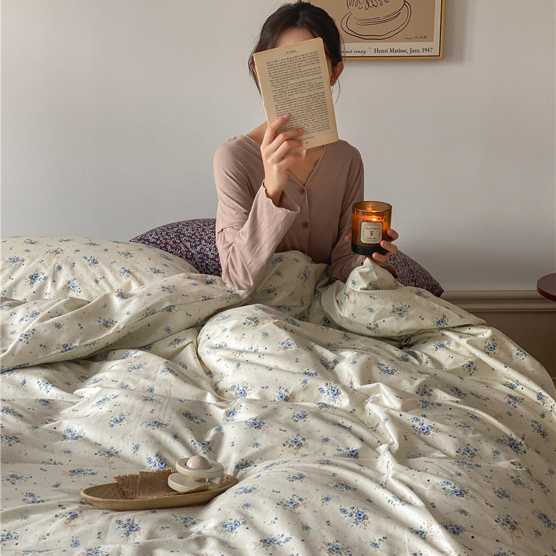 Ivory Blue Floral Cotton Bedding Set – blue floral cotton duvet spread around a seated reader - Roomden