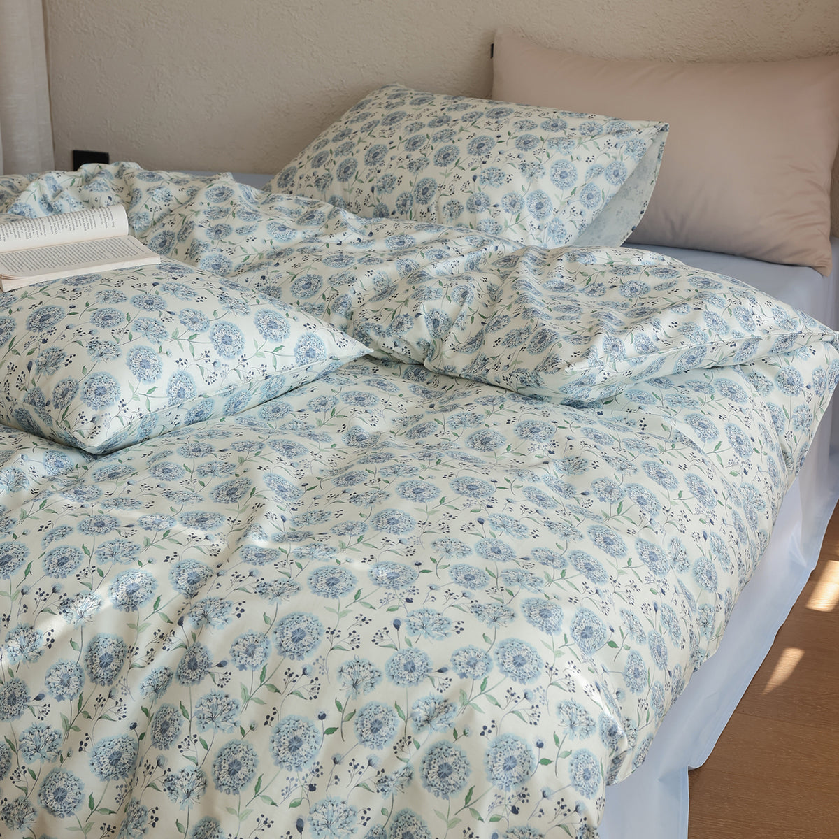 Verbena Botanical Cotton Bedding Set – blue floral pillows and folded duvet with an open book - Roomden