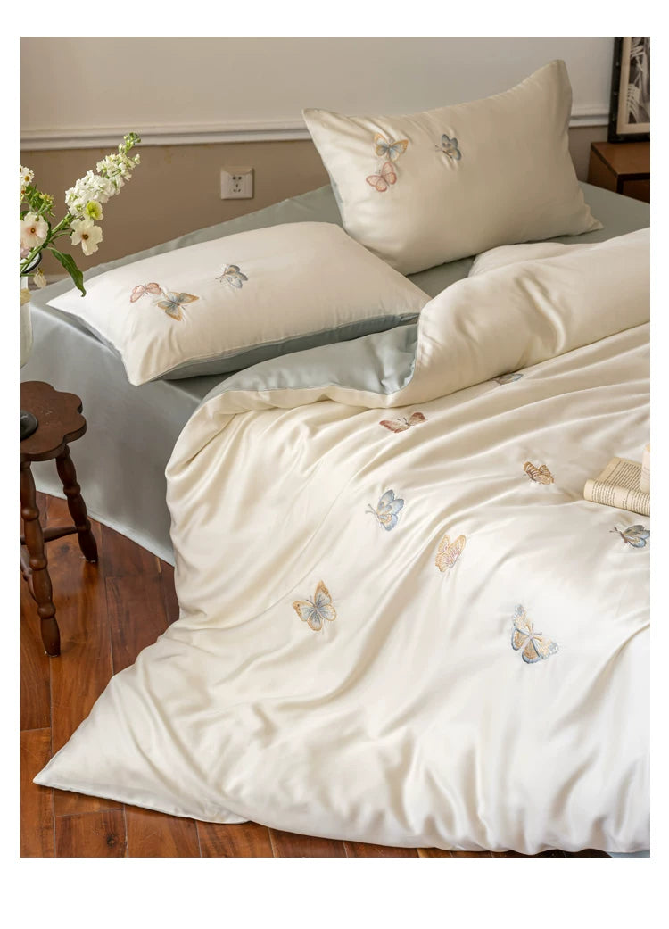 Butterfly embroidered lyocell bedding – Side view of the embroidered duvet and pillow arrangement - Roomden