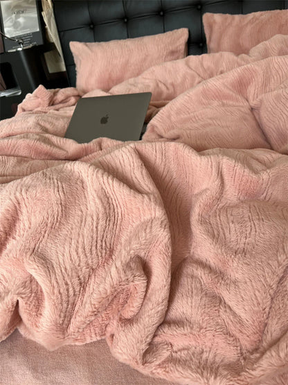 Close-up of a plush, ruched Blush Pink flannel fleece duvet cover with a laptop resting on it. - RoomDen