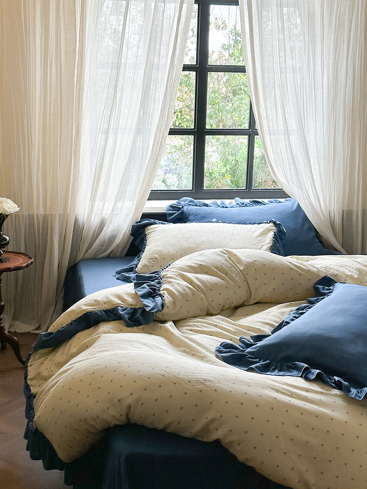 Fleurette Blue Star Sprig Double Gauze Bedding Set – Angled bed view with ivory sprigs and deep blue ruffles - Roomden