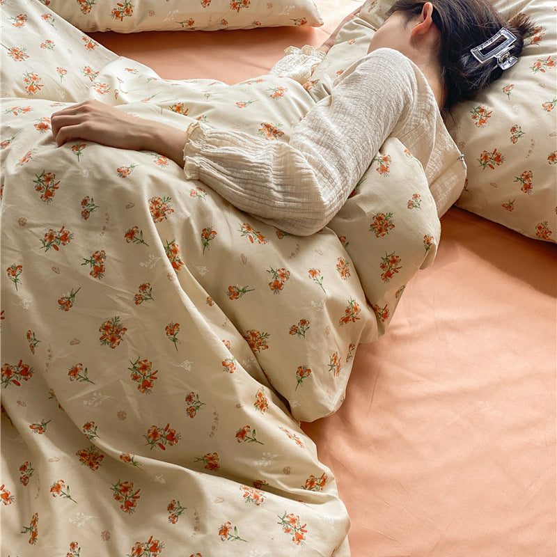 Ivory Peach Floral Cotton Bedding Set – orange floral cotton bedding and matching pillow shown around a resting figure - Roomden