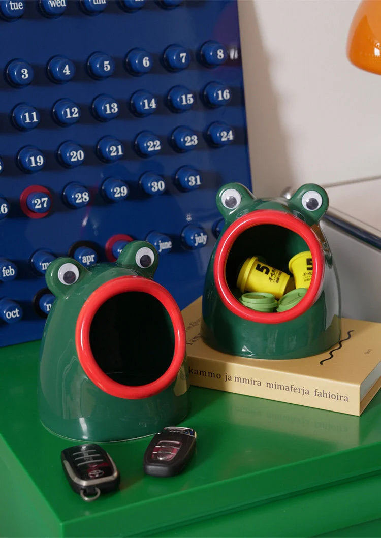 Two green and red ceramic frog organizers on a green desk, holding keys and small items. - RoomDen