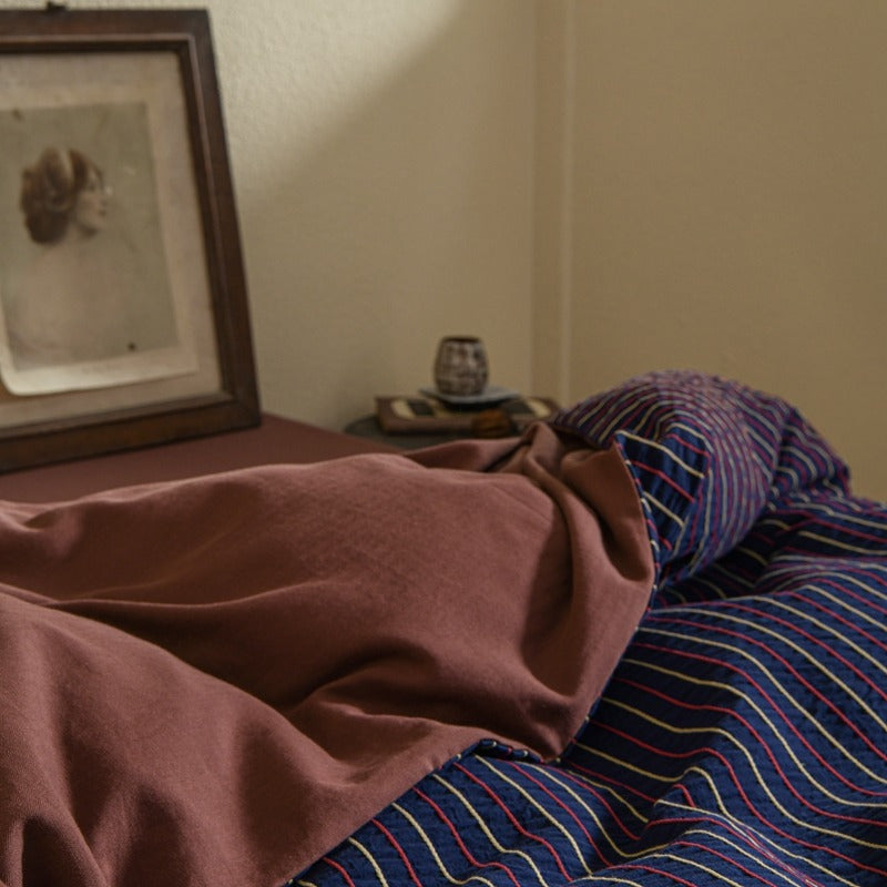Amberlyn Navy Rose Stripe cotton bedding set – angled view of the patterned cotton and plain companion fabric - Roomden