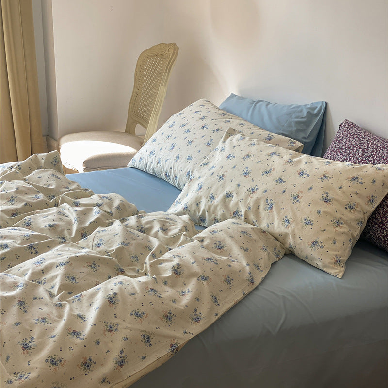 Ivory Blue Floral Cotton Bedding Set – ivory duvet and matching blue floral pillows above a dusty blue sheet - Roomden