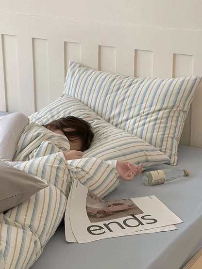 A person sleeping peacefully in the soft Blue Striped Washed Cotton Bedding Set. - RoomDen