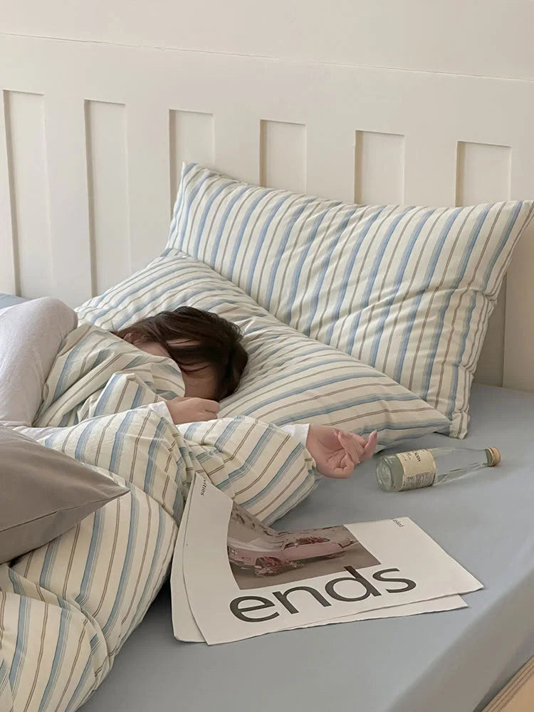 A person sleeping peacefully in the soft Blue Striped Washed Cotton Bedding Set. - RoomDen