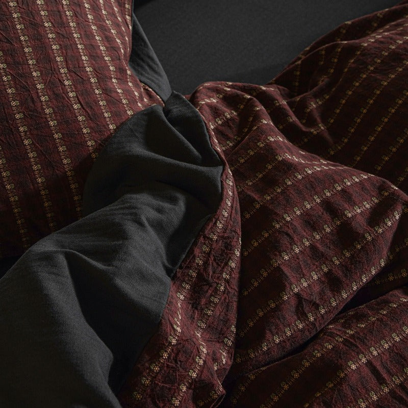 Amberlyn Burgundy Motif Stripe cotton bedding set – angled view of the patterned cotton and plain companion fabric - Roomden