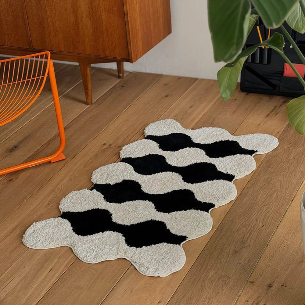 Plush wavy striped shaggy accent rug in black and white with orange wire chair - RoomDen
