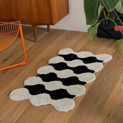 Plush wavy striped shaggy accent rug in black and white with orange wire chair - RoomDen