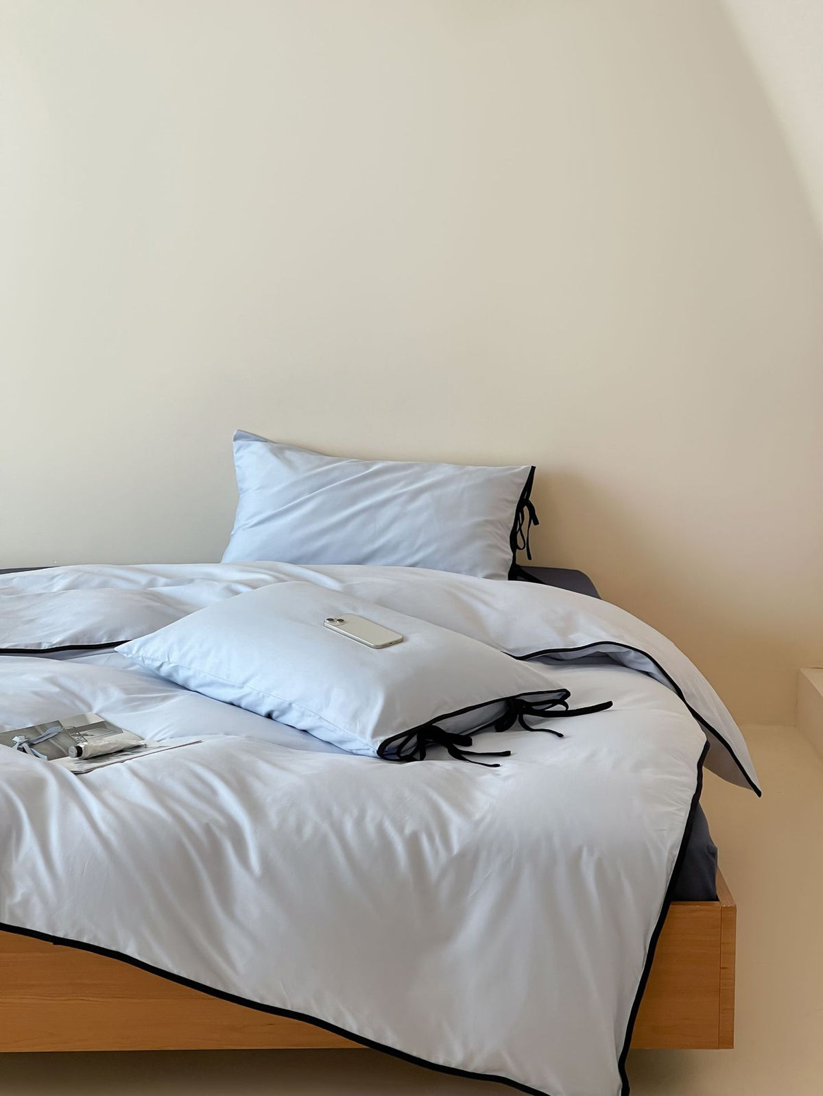 Contrast Tie-Knot Cotton Bedding Set – Blue with Navy Blue Ties, angled blue bedding beside a wall niche - Roomden