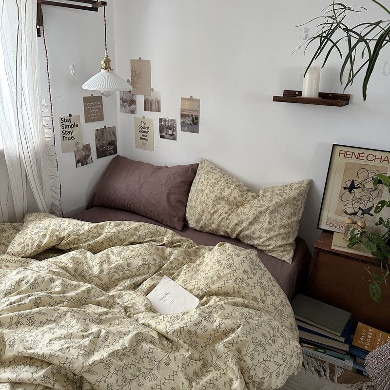 Beige botanical trellis cotton bedding with fine floral outlines and diamond-shaped vines, shown in a bedroom - Roomden