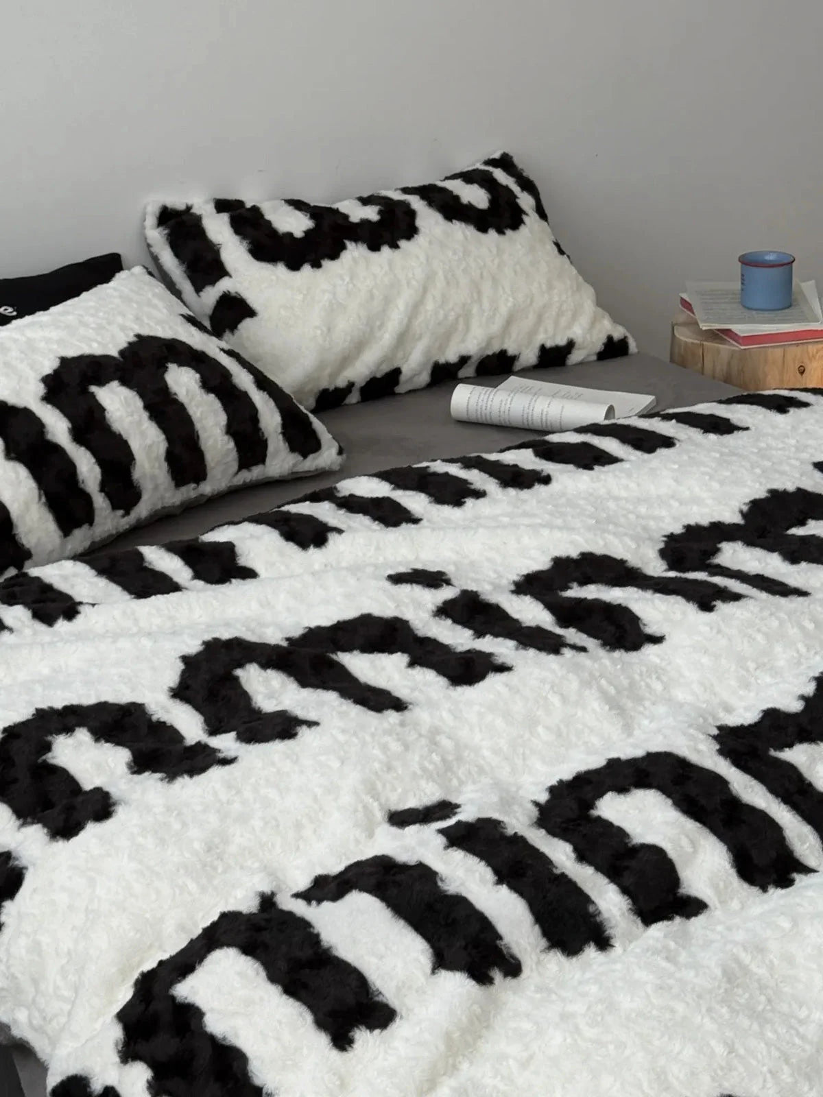 Angled view of the cozy black and white text print flannel fleece duvet cover and pillow shams. - RoomDen