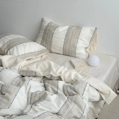 A cozy bed styled with the Oatmeal Beige textured stripe washed cotton bedding set in a bright, minimalist room.