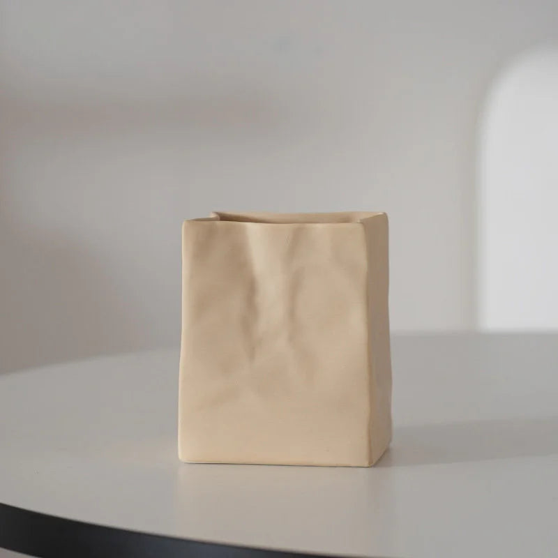 A single khaki crumpled ceramic organizer on a white table with soft lighting. - RoomDen