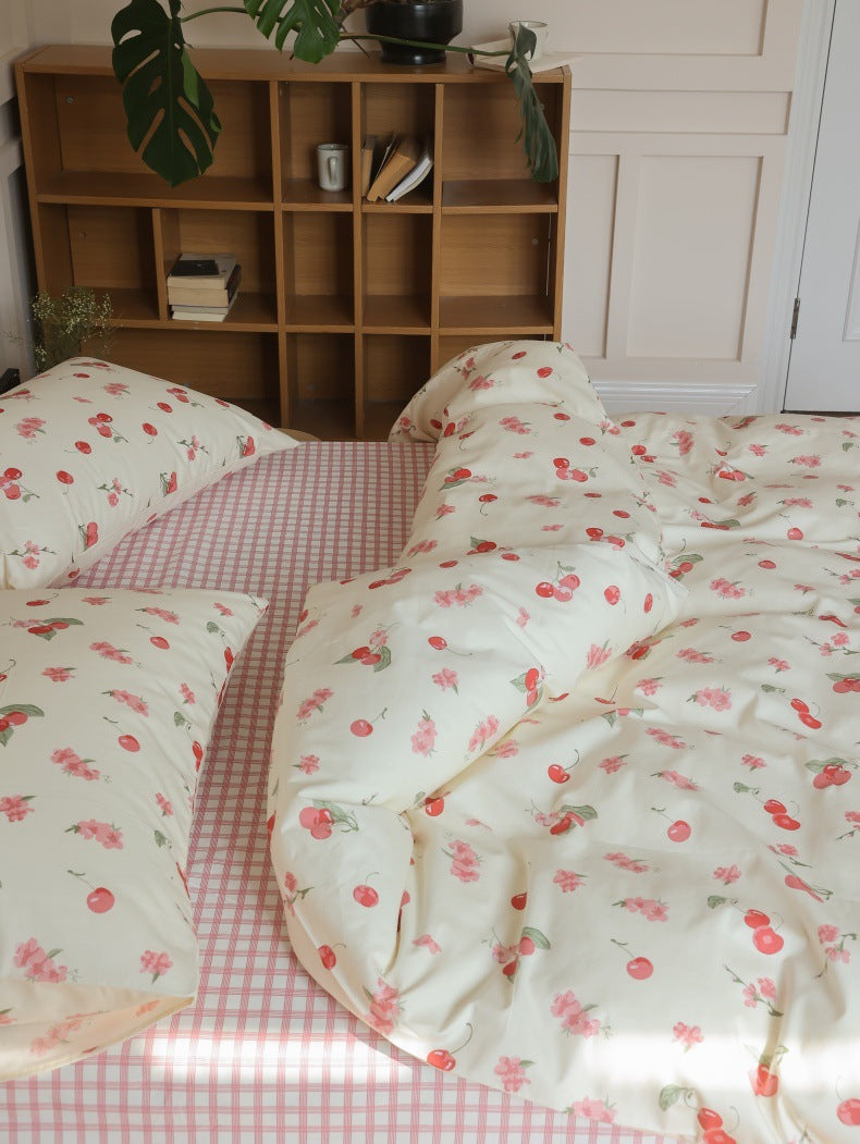 Ivory Cherry Floral Cotton Bedding Set – overhead view of pillows with a pink checked sheet - Roomden