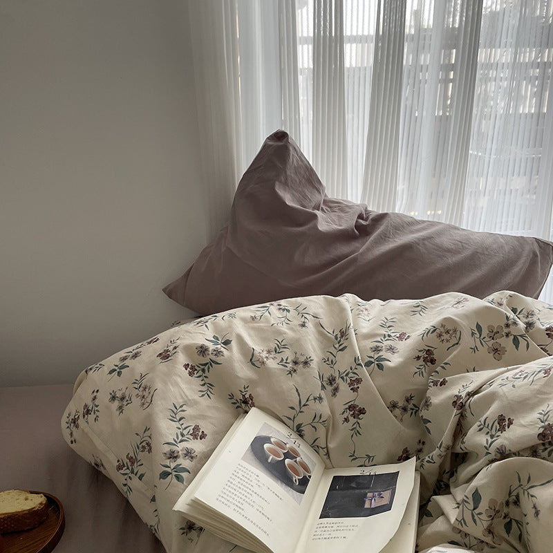 Florhaven Ink Sprig cotton bedding set – window-side view of the patterned duvet and plain taupe pillow - Roomden