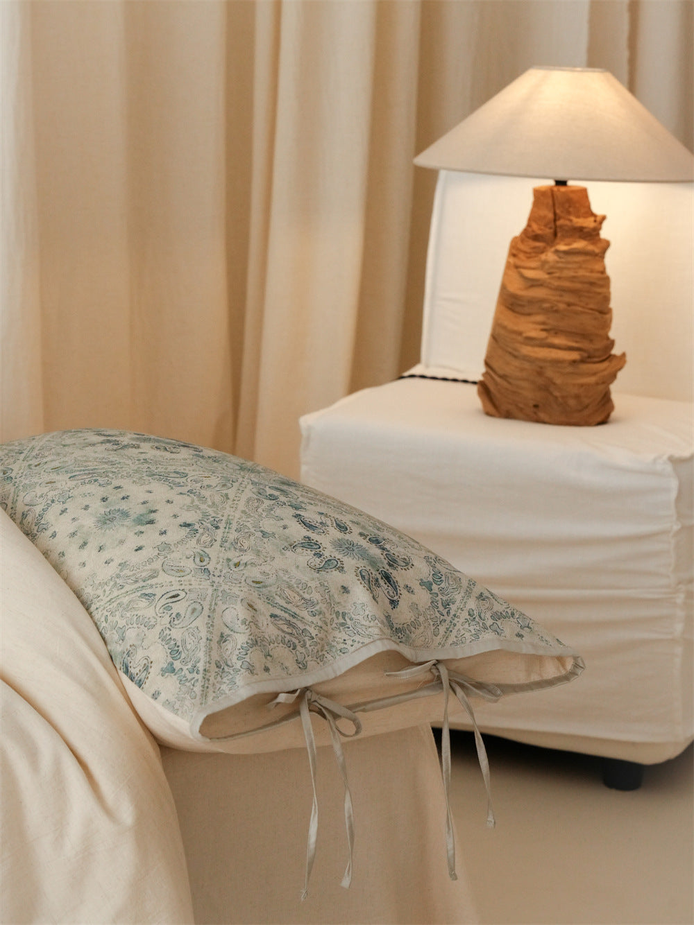 Stillgarden Blue Botanical Scroll Cotton Linen Bedding Set – Pillow and pale ties beside a bedside lamp - Roomden