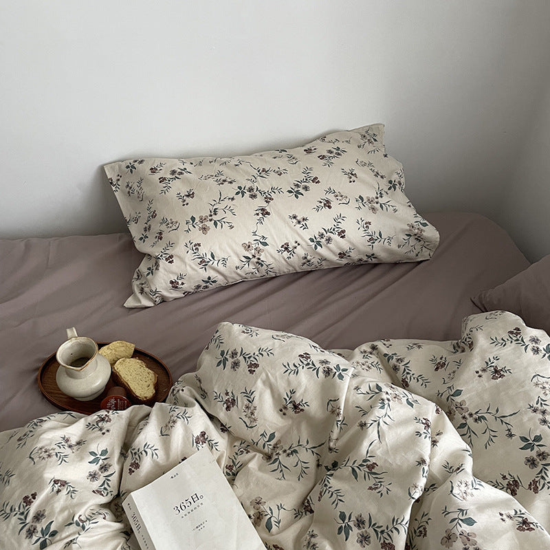 Florhaven Ink Sprig cotton bedding set – overhead view of the botanical pillow and turned duvet - Roomden