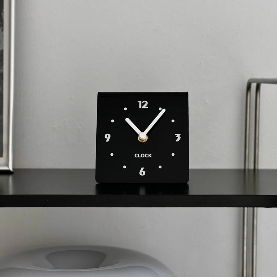 Close-up of the black table clock face with white hands. - RoomDen