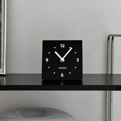 Close-up of the black table clock face with white hands. - RoomDen