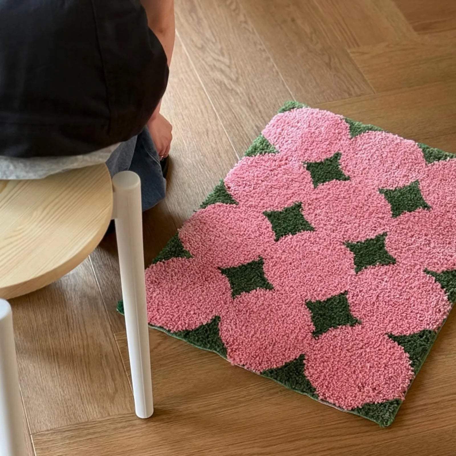 Pink and green floral tufted accent rug on wooden floor - RoomDen