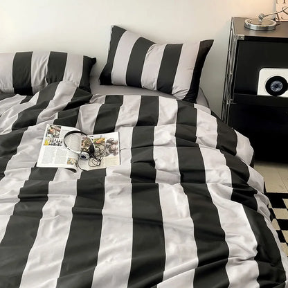Soft Bold Stripe Cotton Bedding Set in Black & Grey on a bed in a minimalist setting - RoomDen