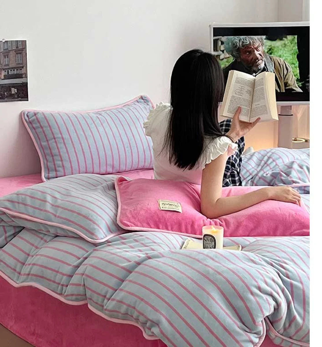 A person reading a book while sitting in the Bubblegum Pink Striped Flannel Fleece Bedding Set. - RoomDen
