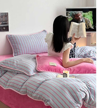 A person reading a book while sitting in the Bubblegum Pink Striped Flannel Fleece Bedding Set. - RoomDen