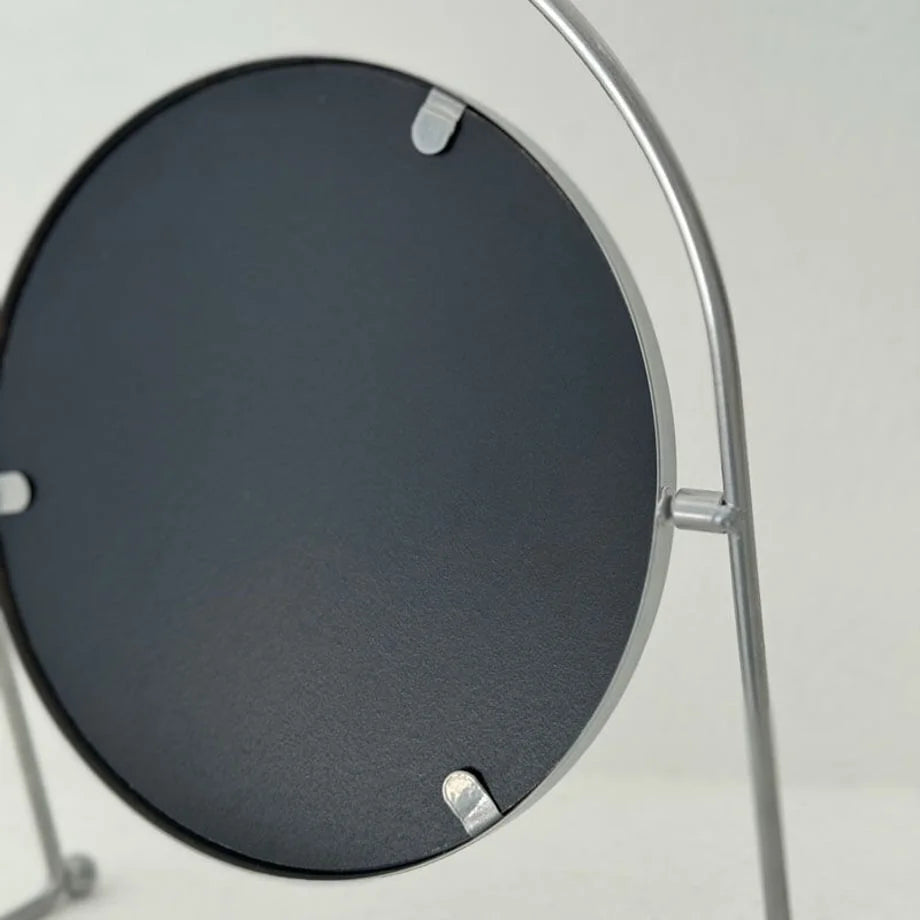 View of the back of the round metal mirror, showing its construction and black backing. - RoomDen