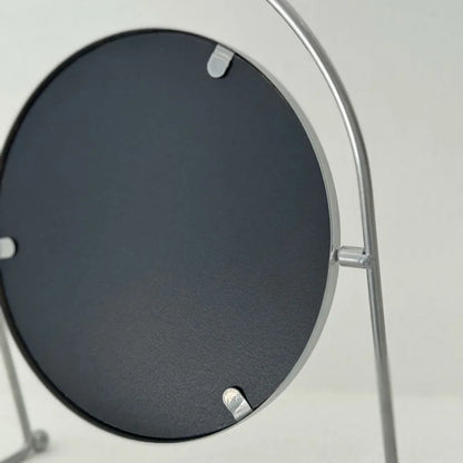 View of the back of the round metal mirror, showing its construction and black backing. - RoomDen