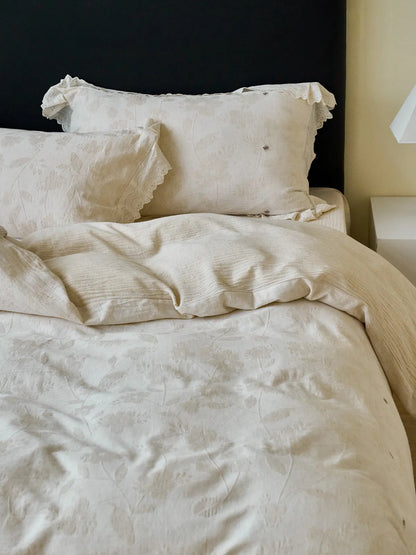 The Antique White linen bedding set styled on a bed, showing the texture of the duvet cover and pillows - RoomDen
