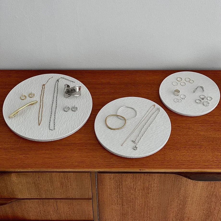 Top-down view of the three white ceramic jewelry trays arranged on a wooden surface, showcasing their organizational capacity. - RoomDen