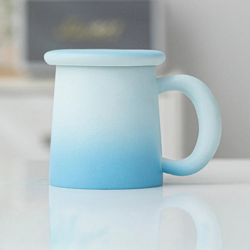 Angled view of the Sky Blue Ombre Frosted Ceramic Mug with lid - RoomDen.