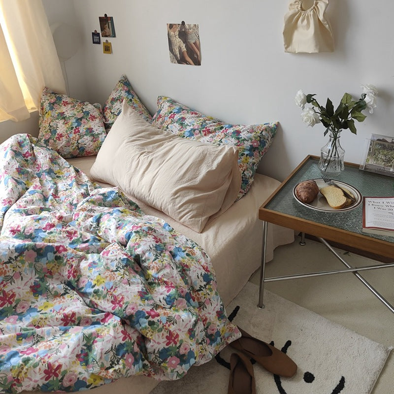 Multicolor Garden Bloom Cotton Bedding Set – angled full bed view beside a wooden table - Roomden