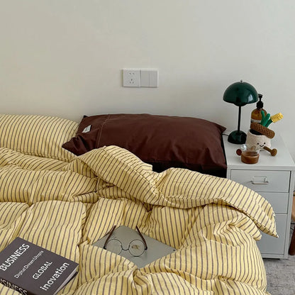 Yellow & Brown Striped Washed Cotton Bedding Set on a bed, styled with a dark green lamp on a white nightstand - RoomDen.