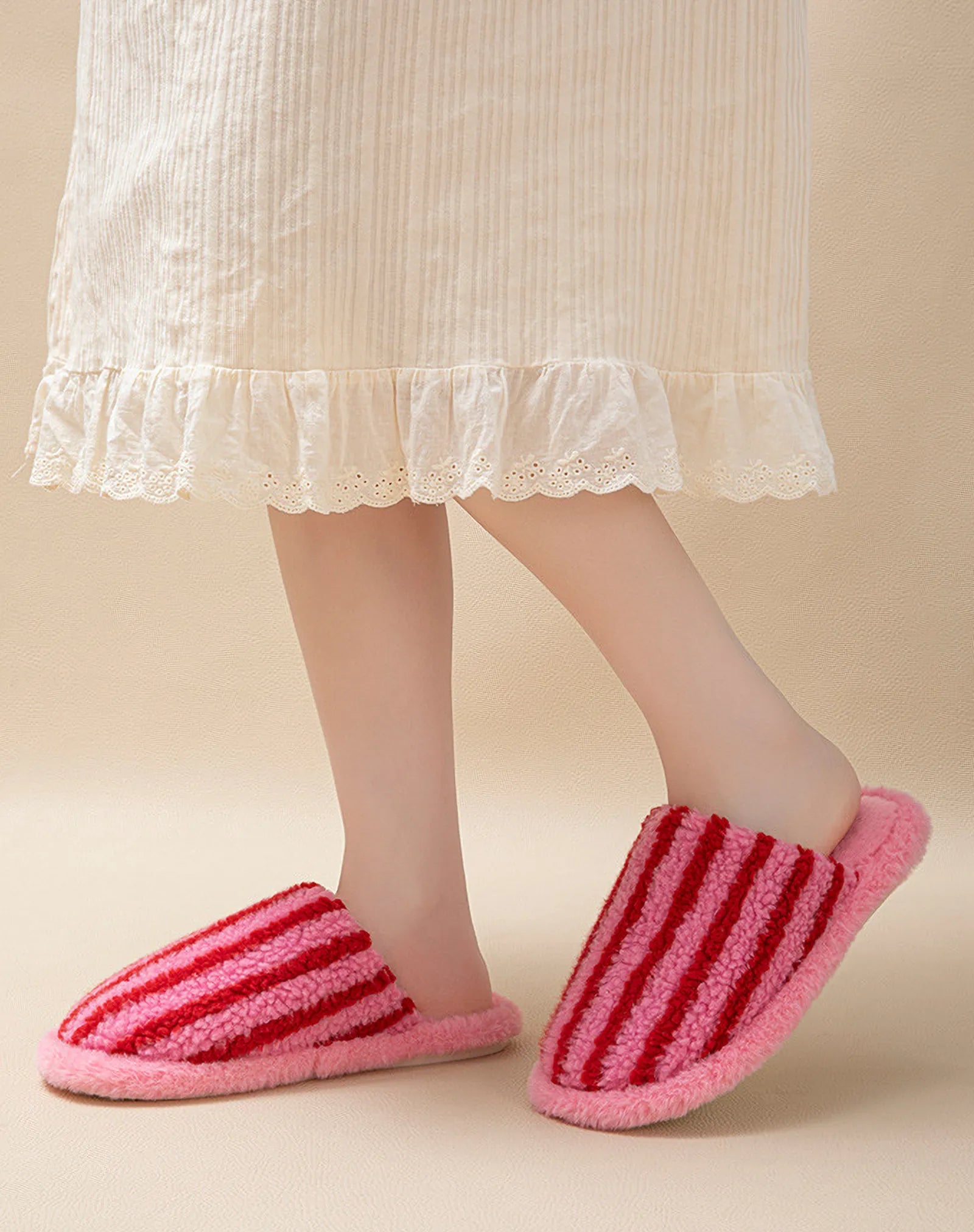 Model wearing Pink and Red striped fuzzy slippers with a white nightgown - RoomDen