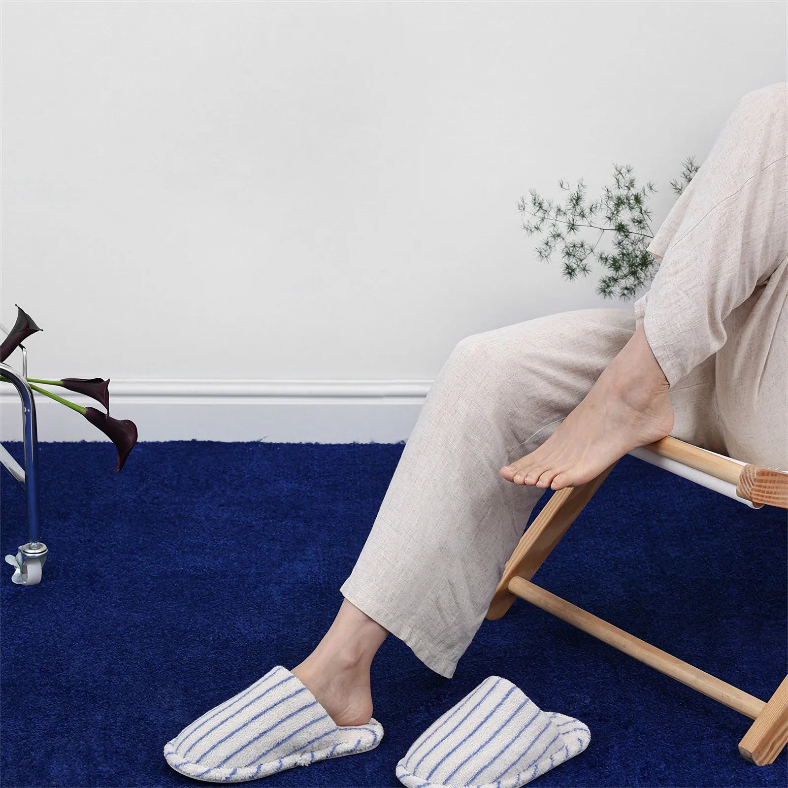 Lifestyle shot of legs resting on chair wearing White and Blue Striped terry slippers