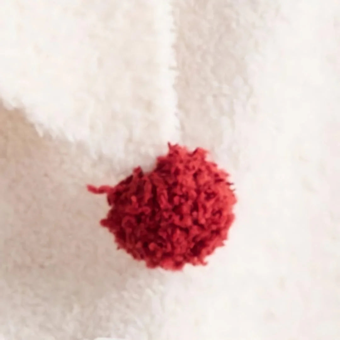 Close-up detail of a fluffy red pom-pom on the Cream White fleece pajama set.